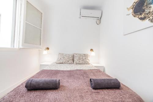 a white bedroom with a large bed with two pillows at Carrer de Santa Madrona, 1 in Barcelona
