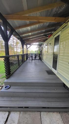 a wooden deck with chairs and a train on it at EKO Domek u Siemion in Raczki