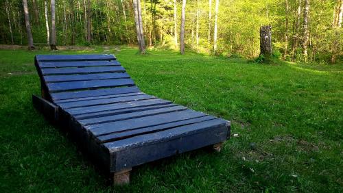 un banco de madera sentado en el césped en un campo en EKO Domek u Siemion, en Raczki