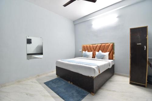 a bedroom with a bed and a tv in it at HOTEL RAMAYAN INN FREE PICKUP FROM AYODHYA DHAM RAILWAY STATION in Ayodhya