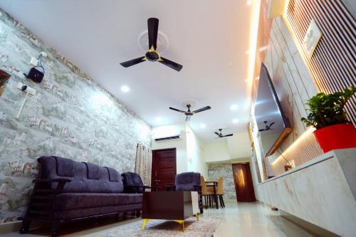 - un salon avec un canapé et un ventilateur de plafond dans l'établissement Tiram Villa, à Visakhapatnam