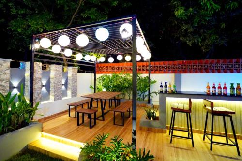 d'une terrasse avec une table, des chaises et un bar. dans l'établissement Tiram Villa, à Visakhapatnam