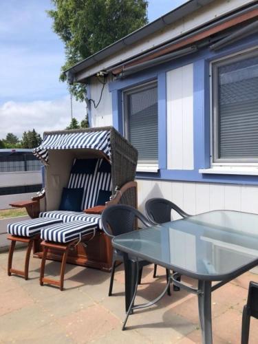 a patio with chairs and a glass table at Strandperle 2 in Loissin