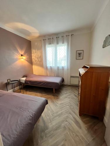 - une chambre avec 2 lits et une commode dans l'établissement Appartement cosy à 2 pas de la mer, idéal familles, à Canet