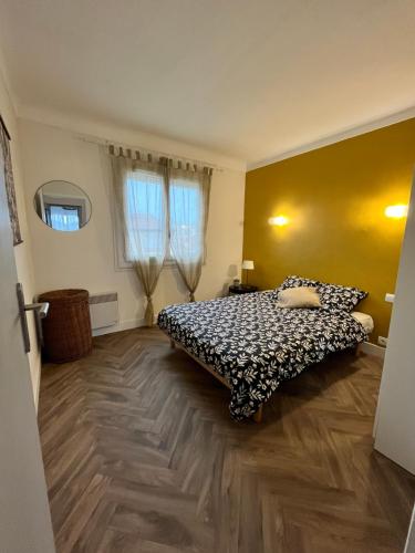 Schlafzimmer mit einem Bett und Holzboden in der Unterkunft Au QALM in Canet-en-Roussillon