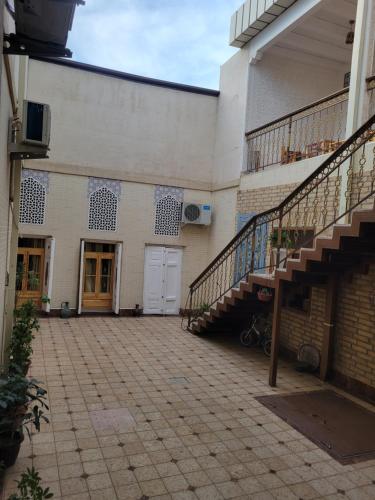 a building with a staircase and a building with a door at ESHONI PIR Boutique HOTEL in Bukhara