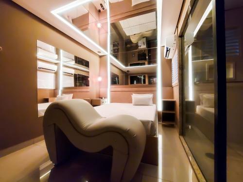 a bedroom with a bed and a couch in a room at Motel Messalina in Sao Paulo