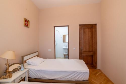 małą sypialnię z łóżkiem i lustrem w obiekcie Hotel Tsinandali Memories w mieście Tsinandali