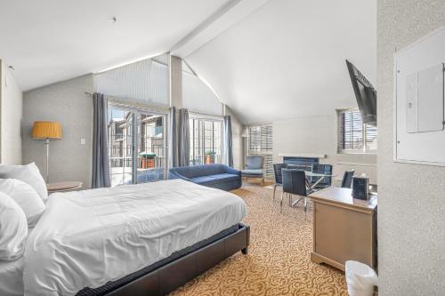 a bedroom with a bed and a desk with a tv at Le Bordeau à Saint-Sauveur in Saint-Sauveur-des-Monts