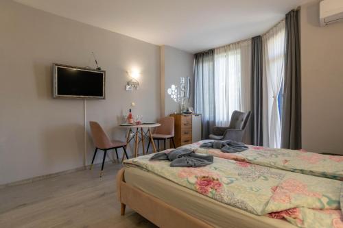 a bedroom with a bed and a table with chairs at Joy Apartment Sunny Beach in Sunny Beach