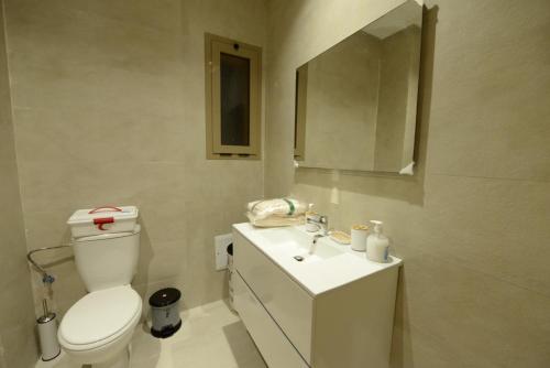 ein Badezimmer mit einem WC, einem Waschbecken und einem Spiegel in der Unterkunft Golf stay with Atlas view at Marrakech! in Marrakesch