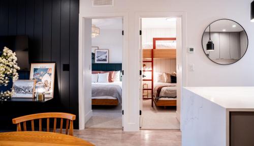 Habitación con dormitorio con cama y espejo. en The Céilí Cottage by Revelstoke Vacations en Revelstoke