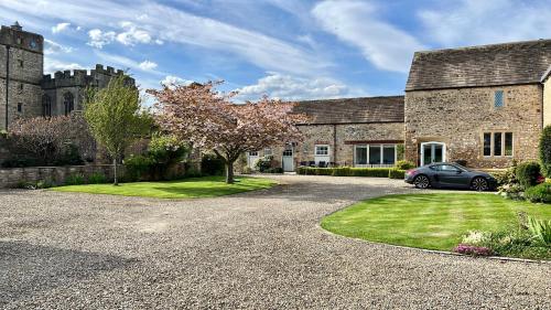 una casa con un coche aparcado delante de ella en The Garden Suites at Snape Castle Mews en Bedale