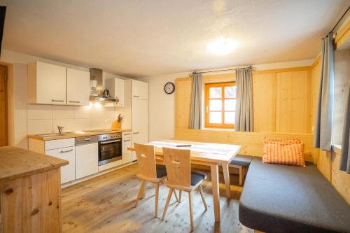 a kitchen with a table and chairs in it at Weberstube Weberhaus Zollhaus Zollstöckl in Obertilliach