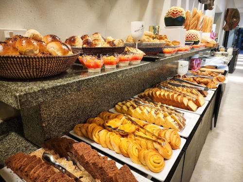 a buffet line with many different types of bread and pastries at Tamala Beach Resort in Kotu