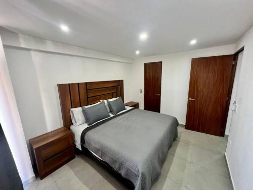 una camera da letto con un letto grande con cuscini blu di Departamento céntrico Vallarta Shaddai a Puerto Vallarta