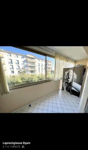 une pièce vide avec une grande fenêtre dans un appartement dans l'établissement STUDIO PORT FREJUS, à Fréjus
