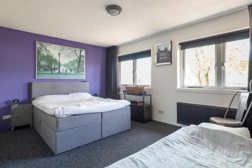 een slaapkamer met 2 bedden en paarse muren bij Beautiful house n.Amsterdam, suitable for families in Hilversum