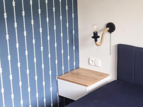 a room with a table and a lamp on a wall at Mazurski Kubryk in Ruciane-Nida