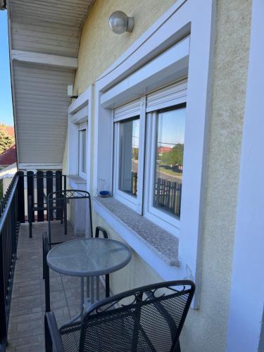 a balcony with tables and chairs and a window at Györgyi Haus in Bük
