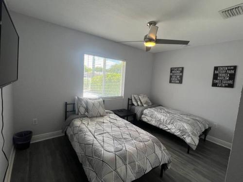 1 dormitorio con 2 camas y ventilador de techo en Stadium Chic Oasis: Modern Retreat in Miami close to Beaches en Miami Gardens