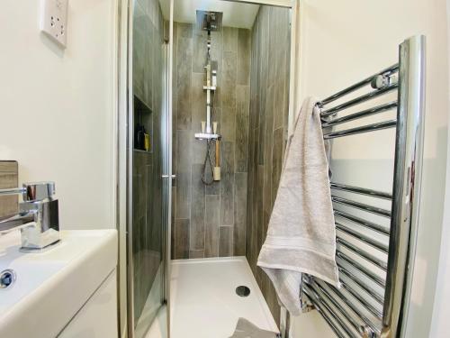 uma casa de banho com um chuveiro, um lavatório e uma toalha em Blossom Lodge - 3 Bedroom Bungalow in Norfolk Perfect for Families and Groups of Friends em Narborough