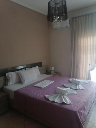 a bedroom with a purple bed with napkins on it at POPI 'S HOME in Skala Sotiros