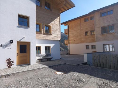 a building with a door and a bench in a courtyard at Weberstube Weberhaus Zollhaus Zollstöckl in Obertilliach