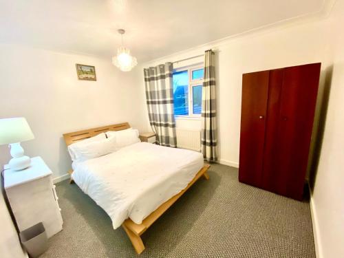 um quarto com uma cama e uma porta vermelha em Luxury Large Four Bedroom Family Home Free Car Park em Luton