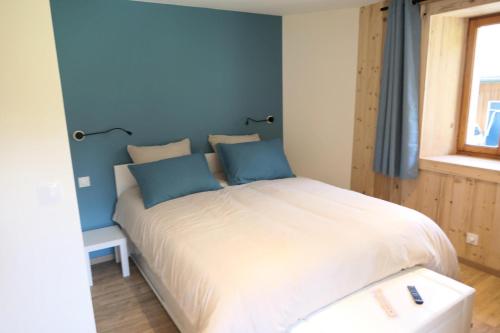 een slaapkamer met een groot bed met blauwe muren bij Chalet Les Margagnes - Chalets pour 8 Personnes 631 in Saint-Gervais-les-Bains