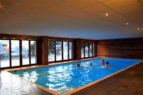 un groupe de personnes dans une grande piscine dans l'établissement Résidence Les Terrasses De Veret - Appartement lumineux · Au pied des pistes · Piscine · Parking inclus · Spa MAE-1651, à Magland