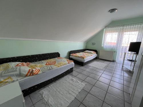 ein Schlafzimmer mit 2 Betten und einem TV. in der Unterkunft Györgyi Haus in Bük