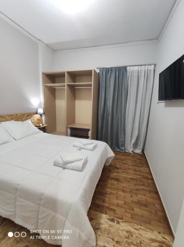 アグリニオにあるanamnesis Agrinioのベッドルーム(大きな白いベッド1台、テレビ付)