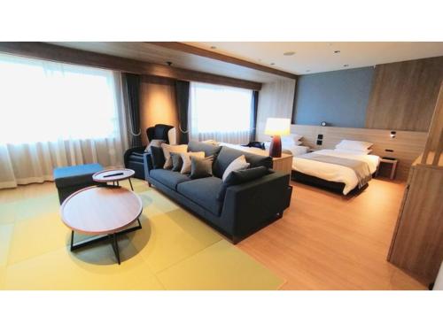 a living room with a couch and a bed at Rishiri Fuji Kanko Hotel - Vacation STAY 63409v in Oshidomari