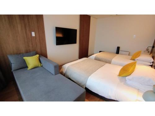 Habitación de hotel con 2 camas y sofá en Rishiri Fuji Kanko Hotel - Vacation STAY 63401v, en Oshidomari