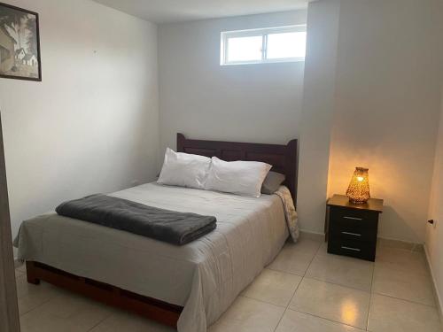 1 dormitorio con 1 cama con mesita de noche y ventana en Apartamento Descanso Central, en Filandia