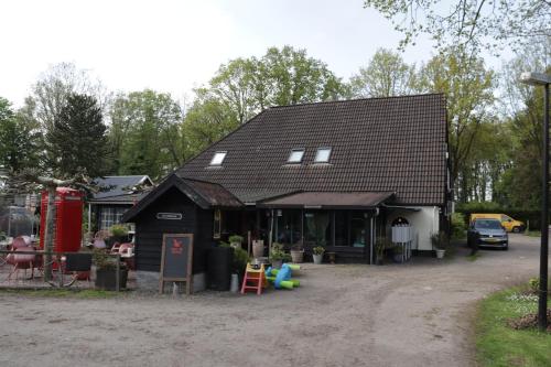 a small black house with a car parked in front of it at Kom heerlijk tot rust in Casa Debonair in Peperga