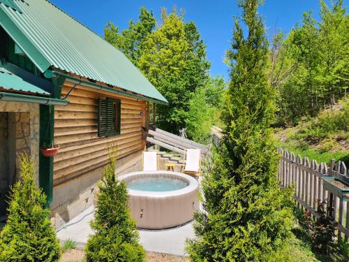 a hot tub in a yard next to a cabin at Koliba Pčelica 1-SPA in Bijelo Polje