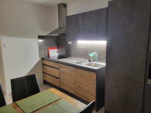una pequeña cocina con fregadero y mesa en Apartma Patrik en Kobarid