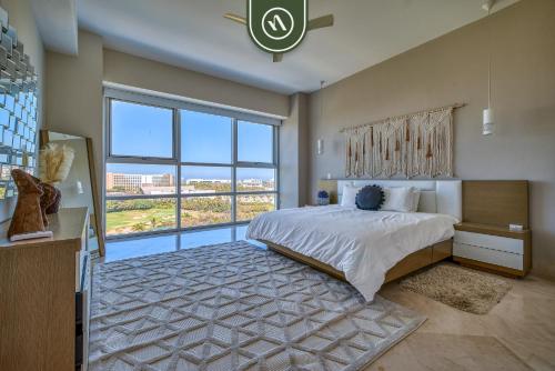 a bedroom with a large bed and a large window at Amazing 2BR Condo with Pool and Access to VIDANTA in Nuevo Vallarta 