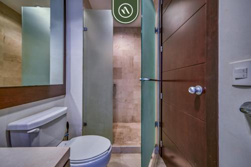 a small bathroom with a toilet and a shower at Amazing 2BR Condo with Pool and Access to VIDANTA in Nuevo Vallarta 