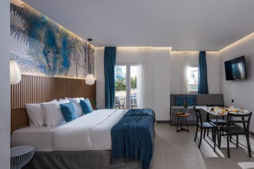 una habitación de hotel con una cama grande y un comedor en Lotus Studios en Mália