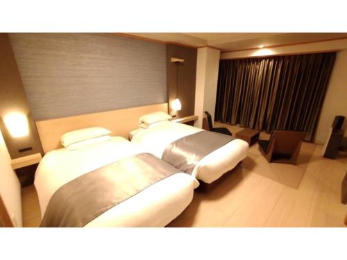 a hotel room with three beds in a room at Rishiri Fuji Kanko Hotel - Vacation STAY 63411v in Oshidomari