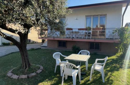 uma mesa e cadeiras em frente a uma casa em Villa Gianfranca - sentiti come a casa em Corno di Rosazzo