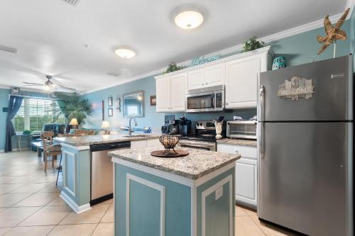a kitchen with white cabinets and a refrigerator at Grand Caribbean 115 by Vacation Homes Collection in Orange Beach