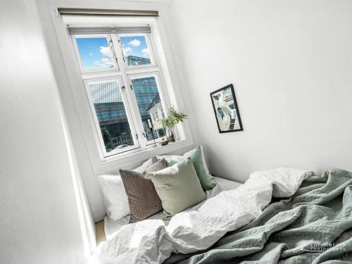 Cama en habitación con ventana y ventana en Cosy and modern apartment in the center of Bergen, en Bergen