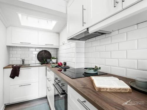 cocina con paredes blancas y encimera de madera en Cosy and modern apartment in the center of Bergen, en Bergen