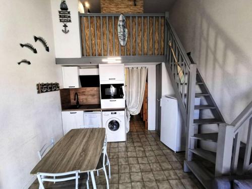 une petite cuisine avec une table et un escalier dans l'établissement Résidence Pinede Du Golf - VILLA T1 CAB MEZZ 5 couchages PORT LEUCATE MAE-9531, à Leucate