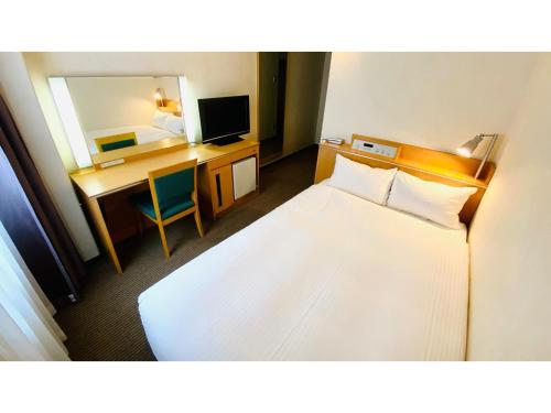 um quarto de hotel com uma cama, uma secretária e um espelho em Valie Hotel Hiroshima - Vacation STAY 50699v em Hiroshima