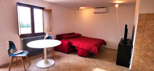 a small bedroom with a red bed and a table at Penthouse loft with view in Rome